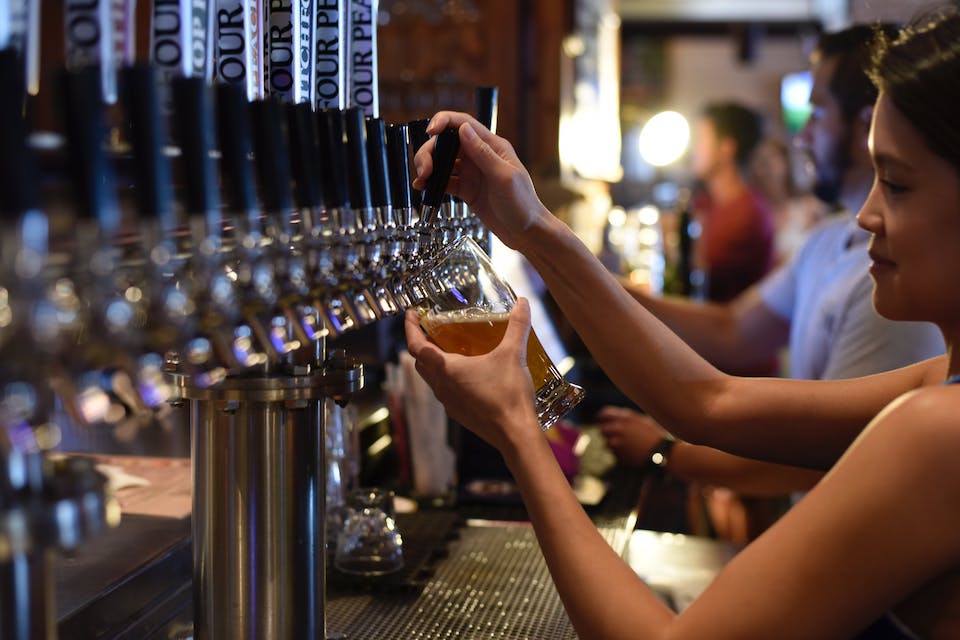 Une serveuse qui remplit une bière